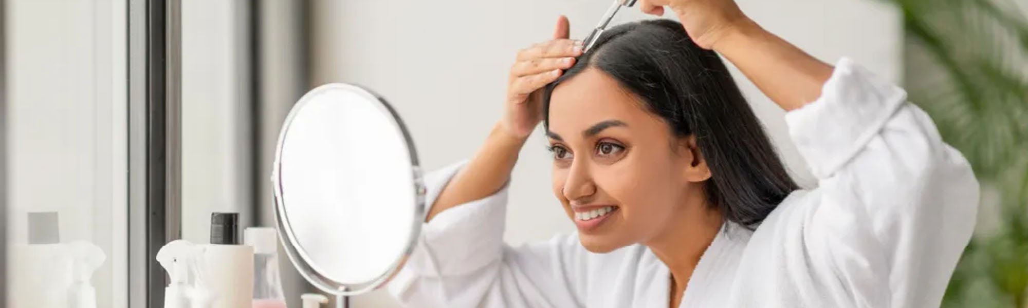 wanita dengan rambut tebal menggunakan serum untuk mencegah rambut rontok