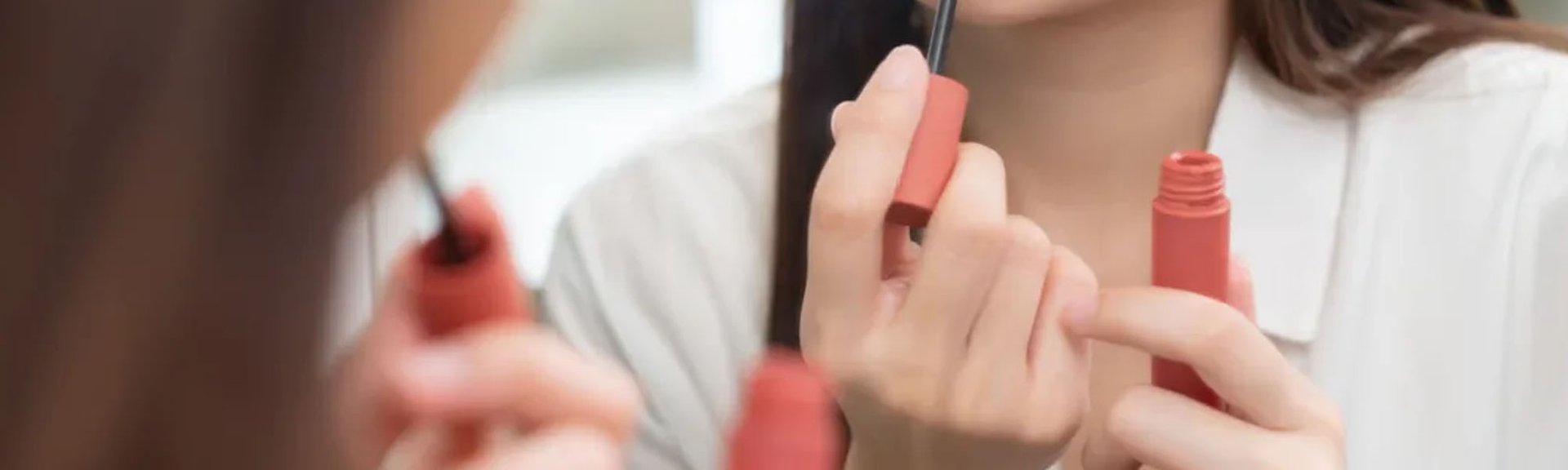 seorang wanita sedang menunjukkan tips pakai lipstick glossy